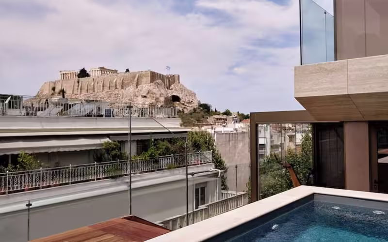 Dakterras met zwembad en zicht op de Akropolis vanaf het hotel