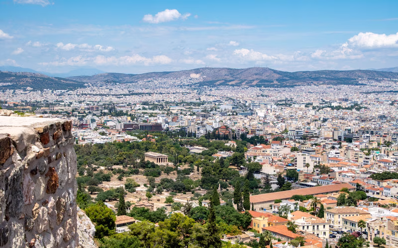 Uitzicht over Athene vanaf een rotsheuvel, met de stad tot aan de bergen