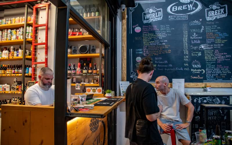 De ingang van Brew Street met het krijtbord en klanten bij de toonbank