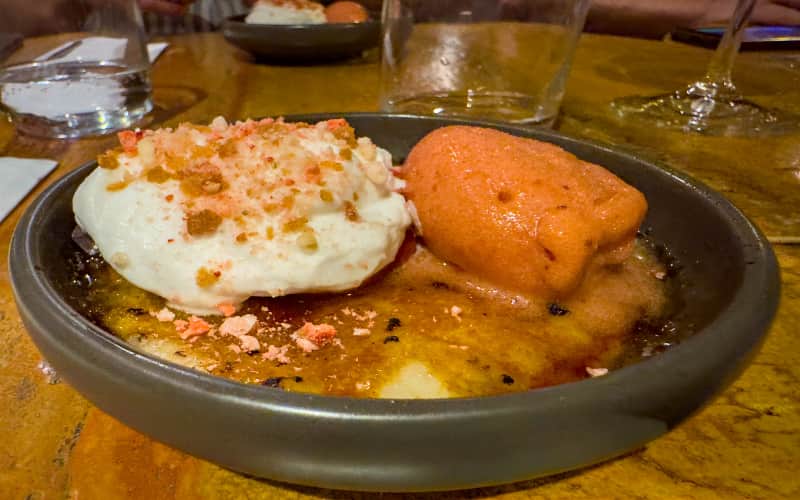 Crème brûlée met een bol ijs in een donkere schaal