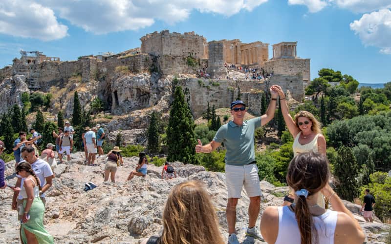 Bezoekers fotograferen de Akropolis vanaf de rots van de Areopagus