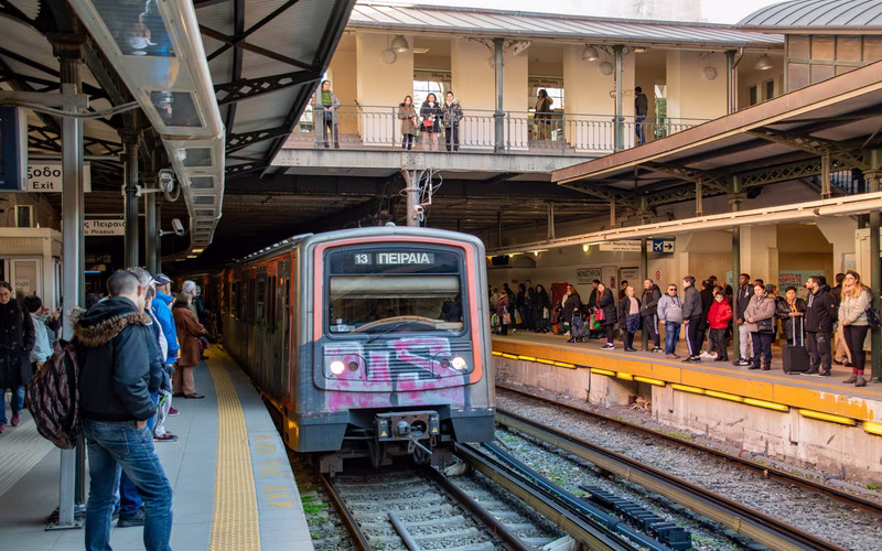 Metroperron in Athene met een binnenrijdende trein en wachtende reizigers