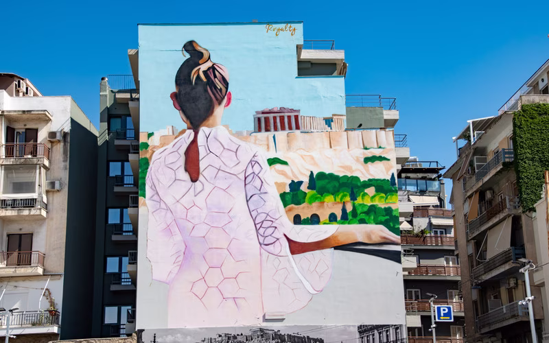 Grote muurschildering van een vrouw in kimono op een zijgevel in Athene