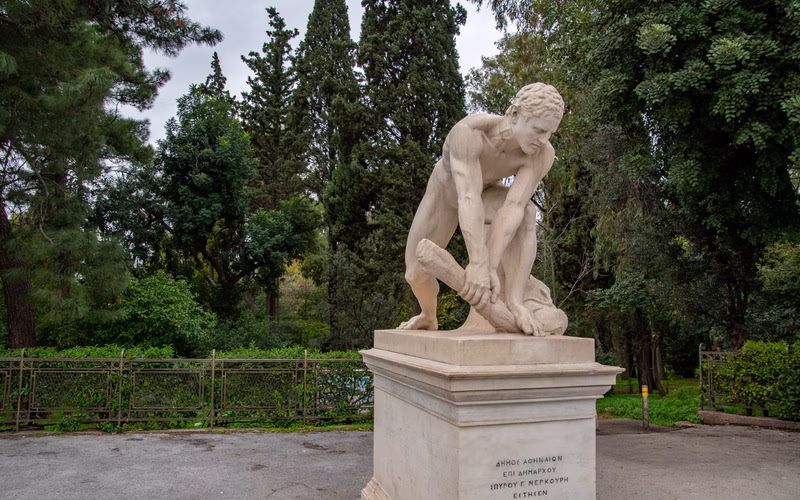 Marmeren beeld van een gehurkte figuur in de Nationale Tuin van Athene