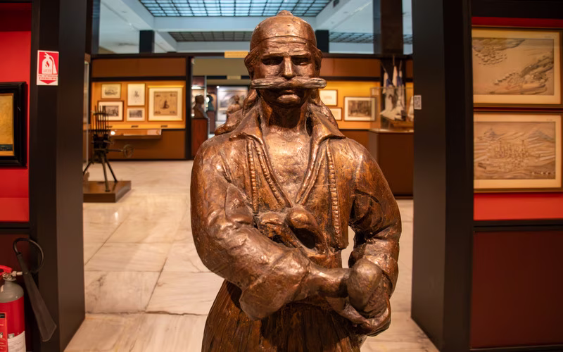 Bronzen beeld van een strijder in een zaal van het Oorlogsmuseum van Athene