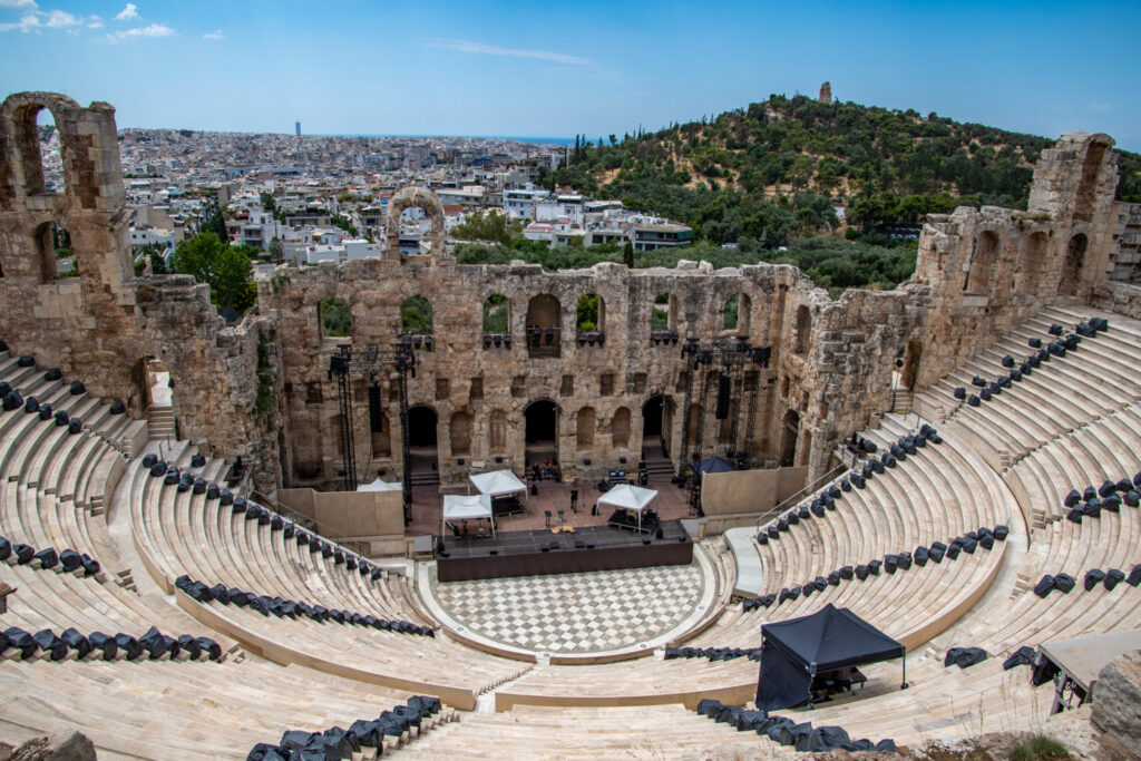 Het Odeon van Herodes Atticus van bovenaf, met de Filopappos-heuvel en de stad op de achtergrond