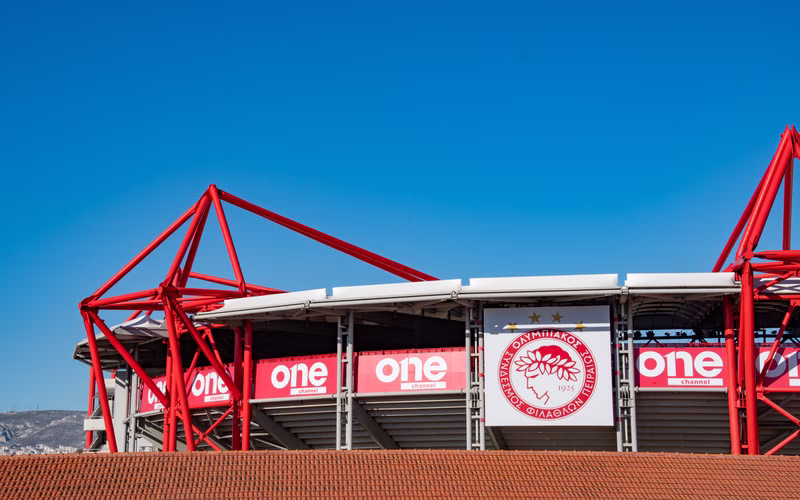 De rode gevel van het Karaiskákisstadion met het embleem van Olympiakos boven de ingang