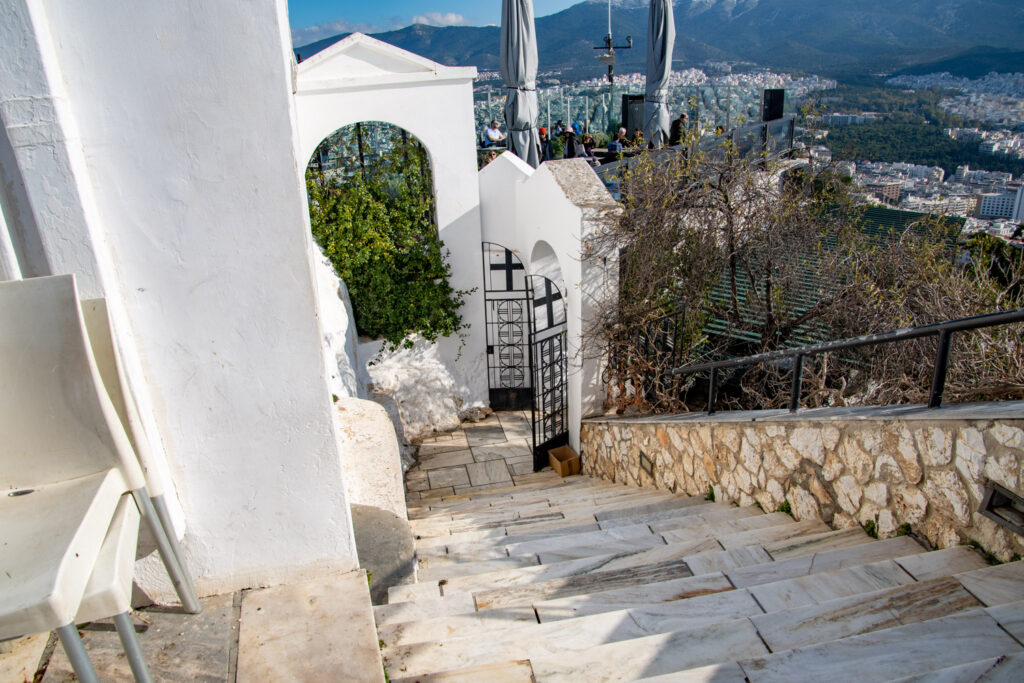 Het witte Agios Georgioskerkje op de top van de Lycabettus met trappen en uitzicht over de stad