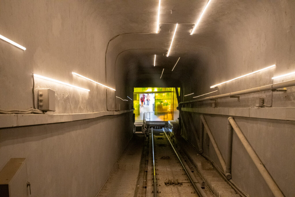 De gele kabeltrein van de Lycabettus in de verlichte tunnel naar de top
