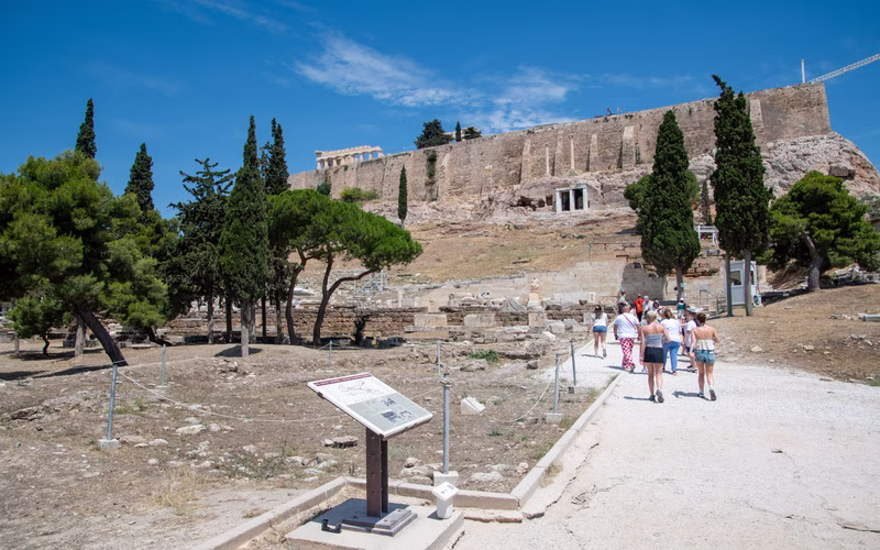 Het archeologische terrein op de zuidhelling van de Akropolis met een informatiebord en het wandelpad langs de resten